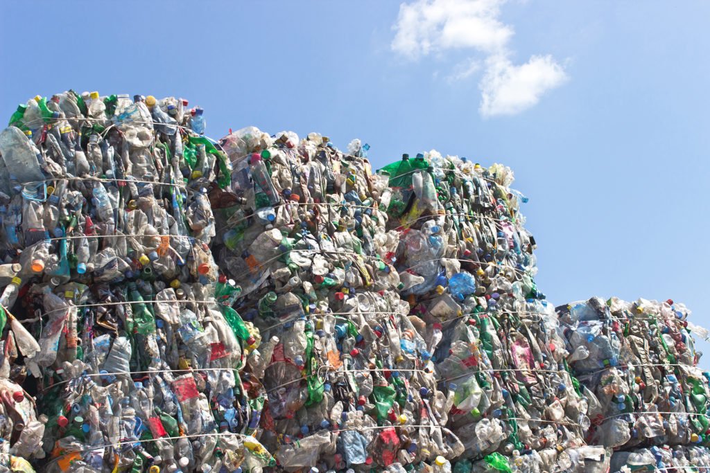 Stack of plastic bottles for recycling against blue sky