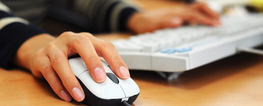 Closeup of hands using a keyboard and mouse